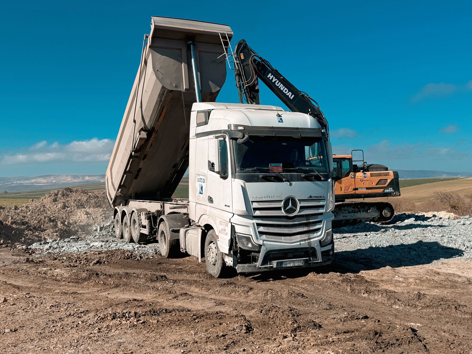 Kipplaster und Bagger auf einer Baustelle